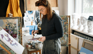 Artists standing in front of painting canvas